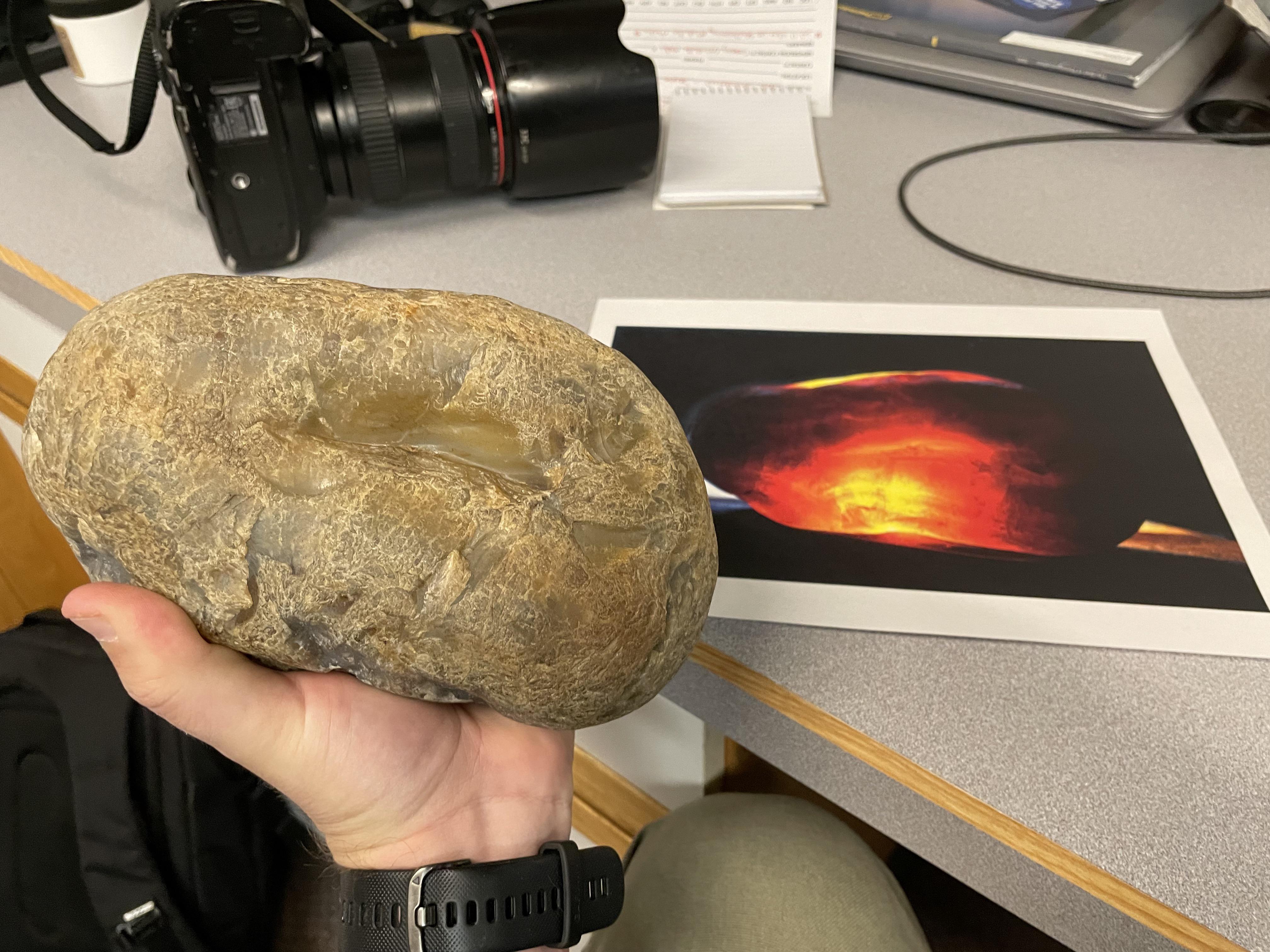 A rockhound taking picture of a rock using a digital camera